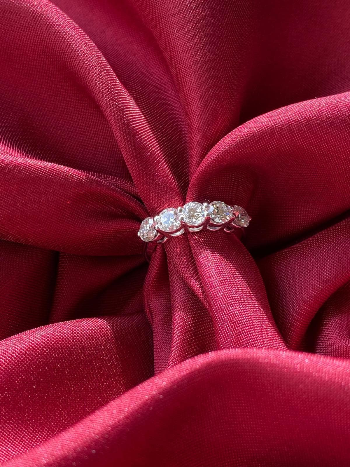 Close-up of a Luméa diamond ring nestled in burgundy silk